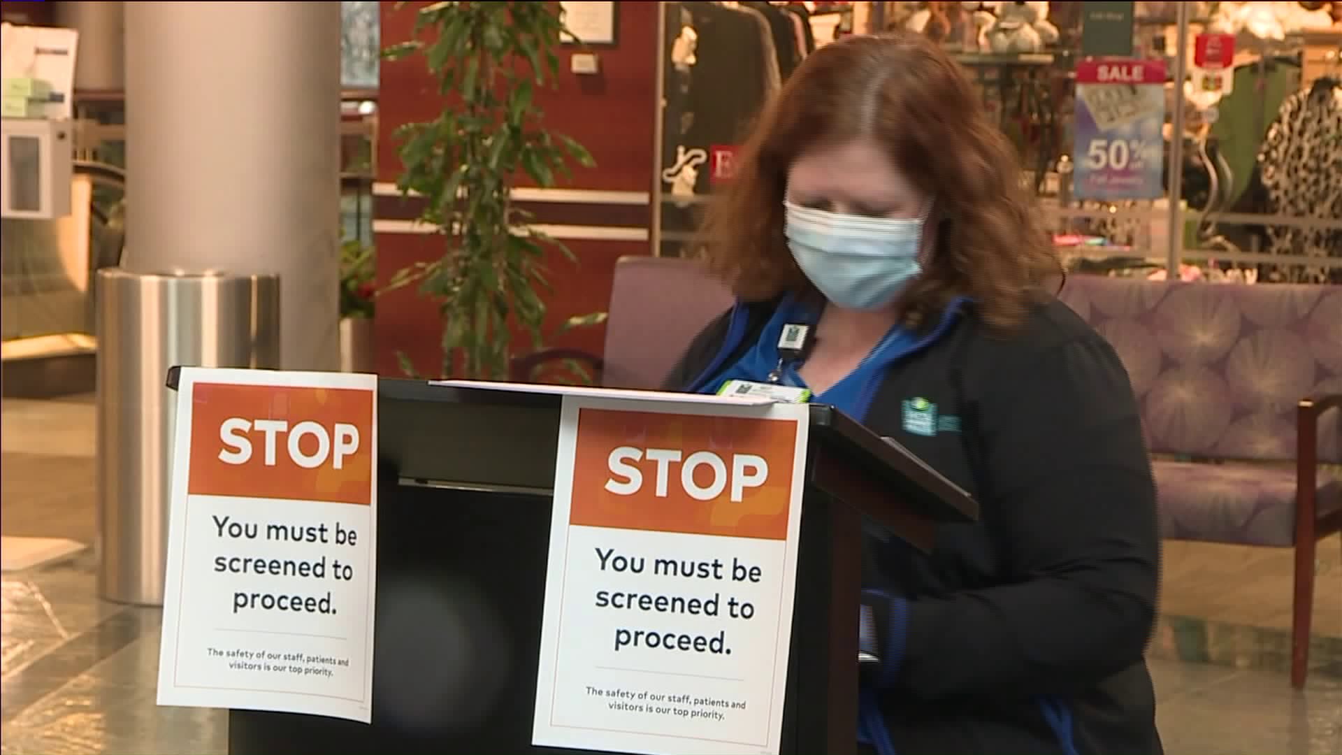 Picture of woman screening people entering hospital